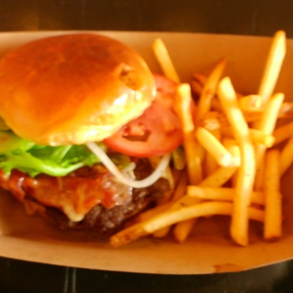 A juicy Ella's Kitchen burger with lettuce, tomato, onion, and cheese, served with golden fries.
